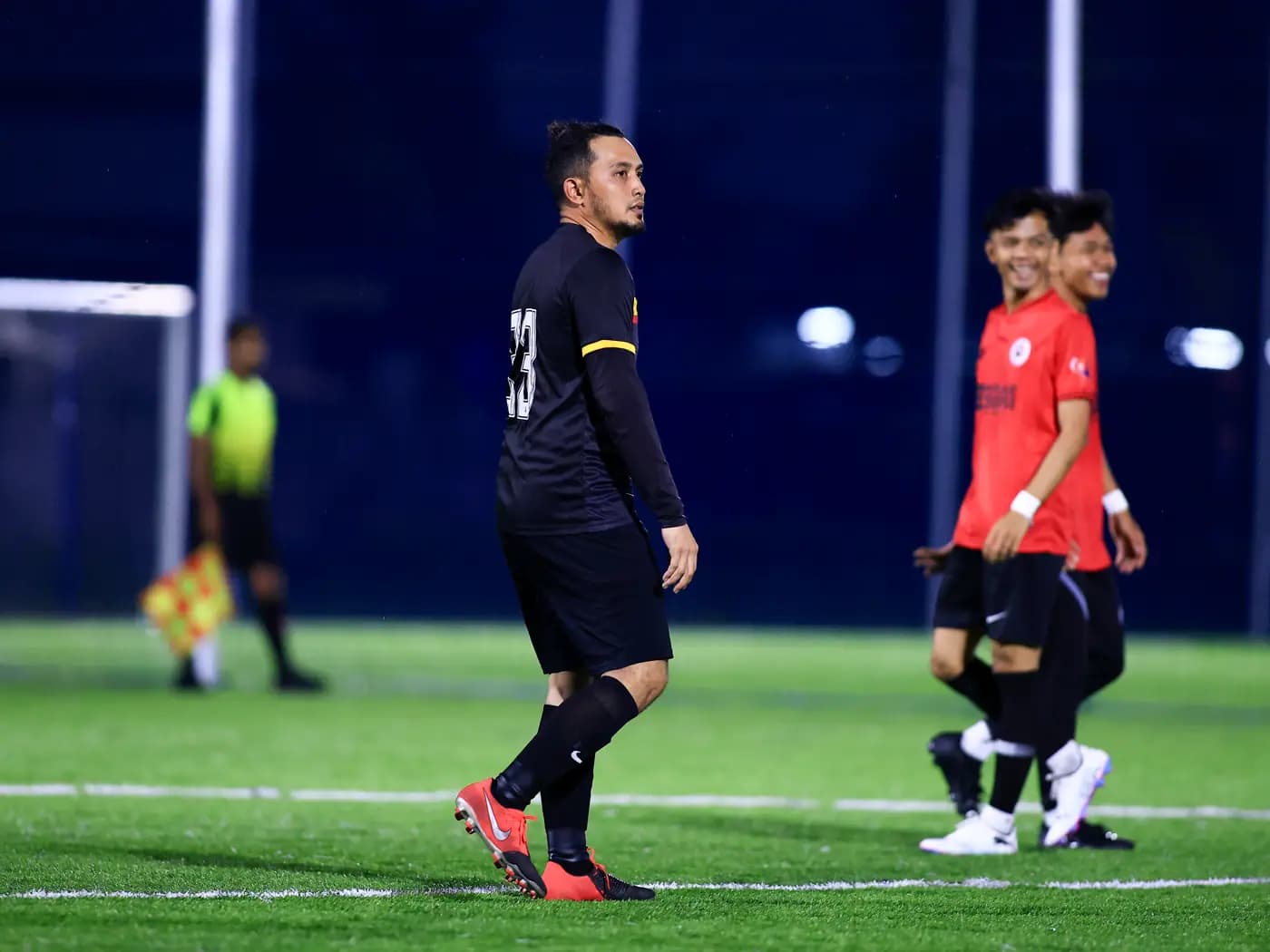 A player walking with the referee behind at ArmourX Sports